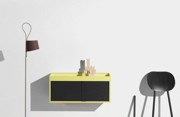 Modern home decor with a minimalist wall cabinet, unique chair, and floor lamp.