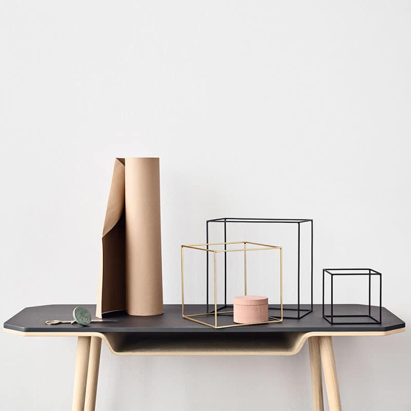 Modern decorative objects on a table, including geometric frames and a rolled paper.