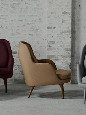 Modern luxury home decor chairs against a brick wall.
