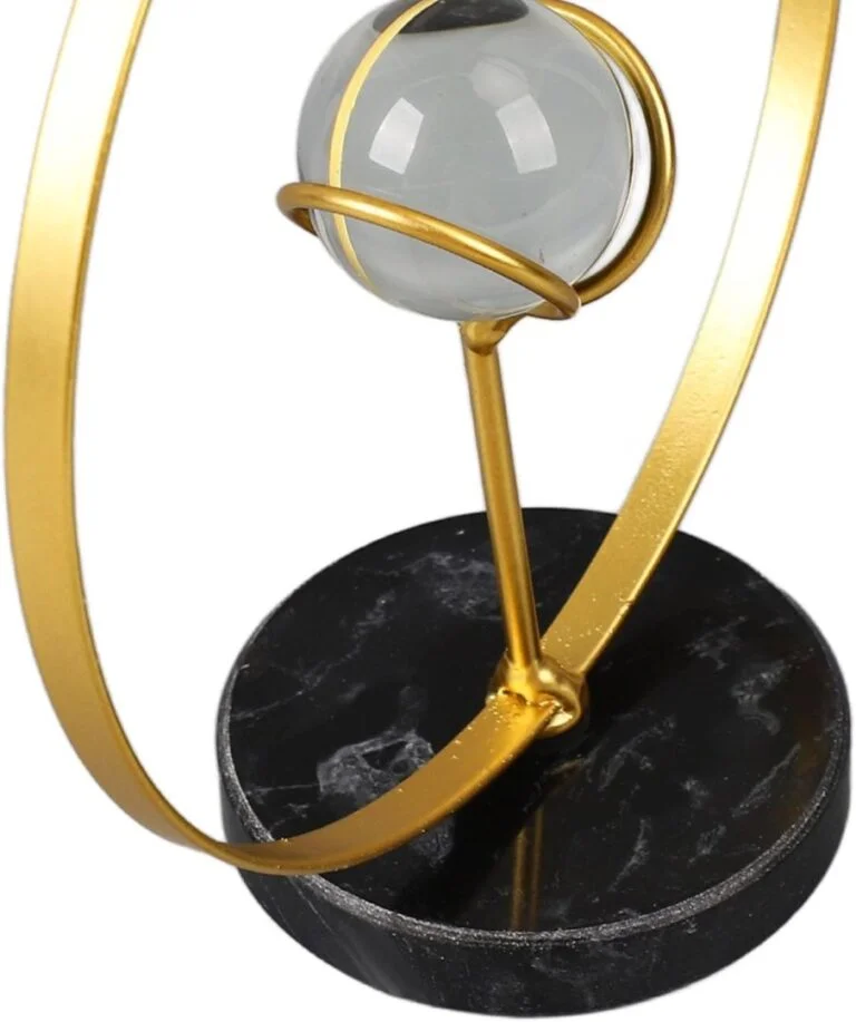 Modern gold and marble decorative sculpture with a spherical accent.
