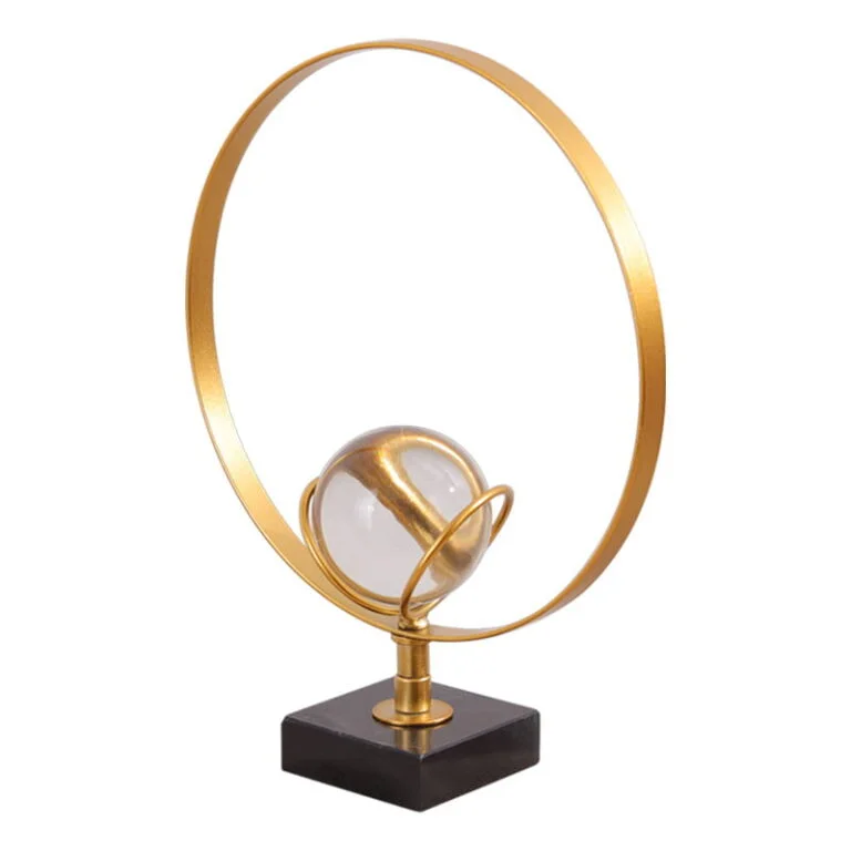 Modern gold decorative sculpture with circular design and crystal sphere on a black base.