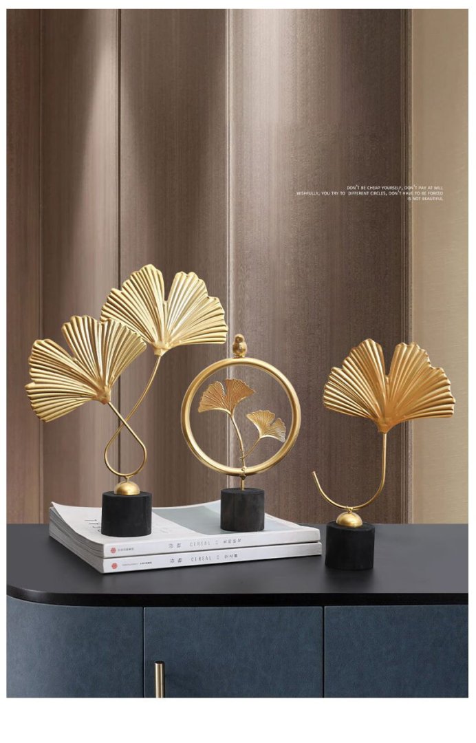 Elegant gold leaf sculptures on a modern blue cabinet, enhancing luxury home decor.