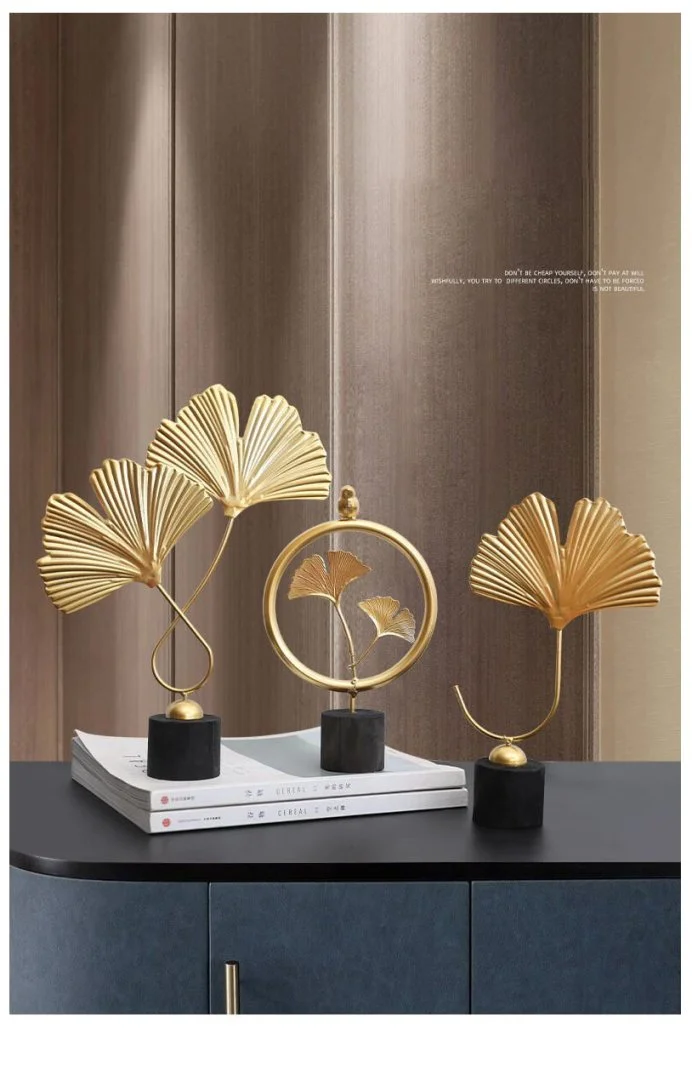 Elegant gold leaf sculptures on a modern blue cabinet, enhancing luxury home decor.