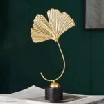 Elegant gold leaf sculpture on a black base, modern home decor accessory.
