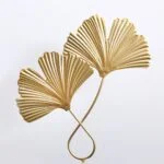Gold metal wall art featuring two fan-shaped leaves, perfect for modern and luxury home decor.