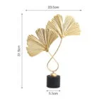 Gold decorative sculpture with fan-shaped leaves on a black base.