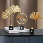 Elegant gold leaf sculptures on a table, modern home decor accents.