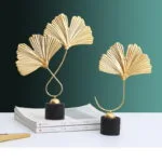 Gold leaf sculptures on books, modern home decor.