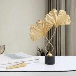 Elegant gold leaf sculpture on a black base, modern home decor accent.