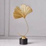 Gold decorative sculpture on black base, modern home decor accessory.