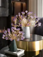 Elegant decorative ornaments with purple crystal flowers in marble vases on a modern table.