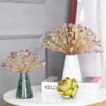 Elegant decorative ornaments with gold branches and purple accents on a table.