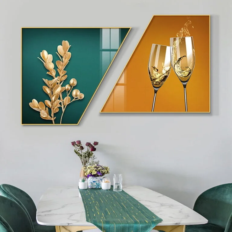 Modern wall art with gold leaves and champagne glasses in geometric frames above a dining table.