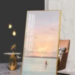 Modern framed wall art with sunset and sailboat, luxury home decor.