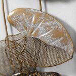 Modern gold and silver decorative wall art with leaf design.