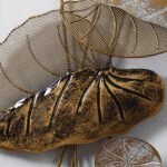 Modern gold metal wall art with leaf design, perfect for luxury home decor.