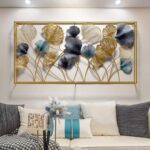 Modern gold and blue floral metal wall art in a living room setting.