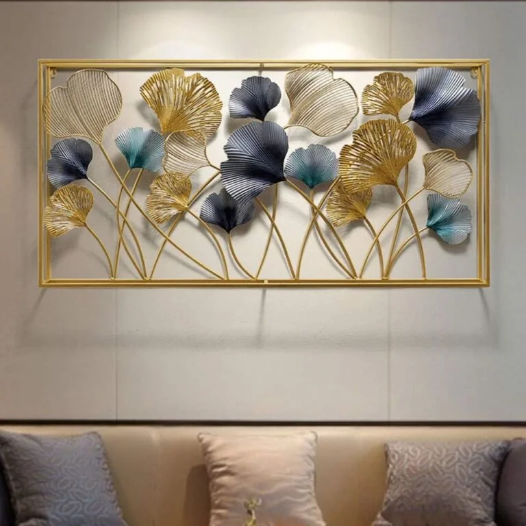 Modern gold and blue metal wall art with floral design in a living room setting.