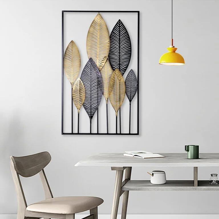 Modern metal wall art with leaf design in a minimalist dining room setting.
