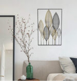 Modern metal wall art with leaf design in a bedroom setting.
