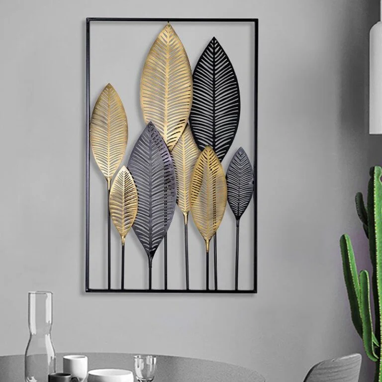 Modern metal wall art with gold and black leaf design in a sleek frame.