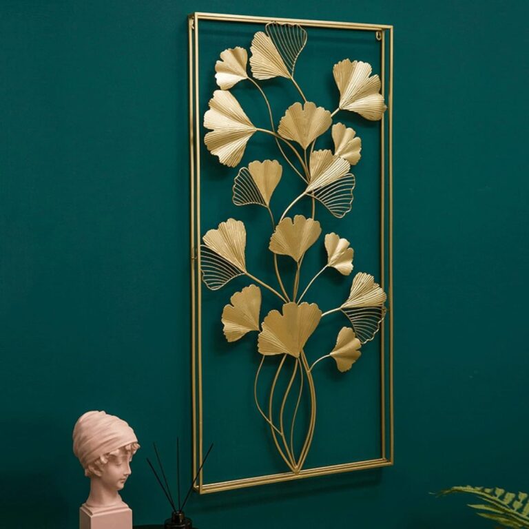 Gold metal wall art with leaf design on a teal wall, modern home decor.