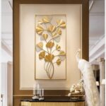 Gold metal wall art with leaf design in a modern living room setting.