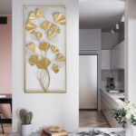 Gold metal wall art with leaf design in modern kitchen setting.