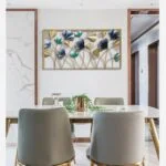 Modern dining room with floral metal wall art and elegant decor.