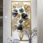 Modern luxury metal wall art with gold and teal leaf design in a gold frame.