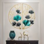 Modern luxury wall art with gold and teal leaf design, decorative vases, and deer figurines.
