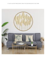 Modern living room with gold leaf wall art, grey sofa, and decorative cushions.