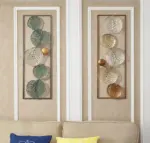 Modern metal wall art with circular designs in a living room setting.
