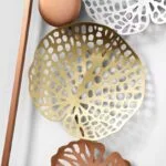 Modern decorative wall art with gold and copper accents, featuring intricate cut-out patterns.