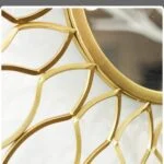 Gold decorative wall mirror with intricate design, modern home decor.
