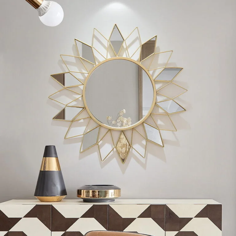 Modern decorative wall mirror with geometric gold frame above a stylish console table.