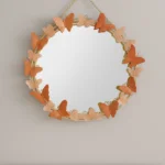 Round decorative wall mirror with butterfly accents, ideal for modern home decor.