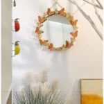 Decorative wall mirror with butterfly design in modern home decor setting.
