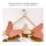 Decorative wall mirror with butterfly accents and gold chain.