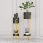 Modern gold and black indoor planters with plants for luxury home decor.