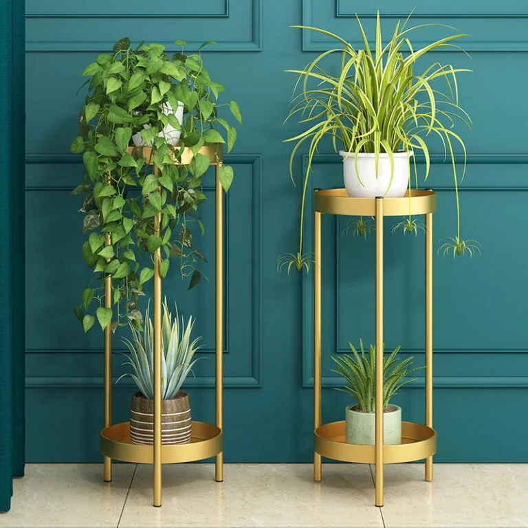 Modern gold indoor planters with green plants against a teal wall.