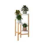 Modern wooden plant stand with three potted plants, ideal for home decor.