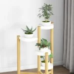 Modern wooden plant stand with three white planters in a bright room.