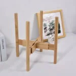 Modern wooden stand with framed art and clock on a shelf, ideal for home decor.