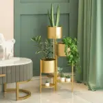 Modern gold indoor planters with green plants in a stylish living room.