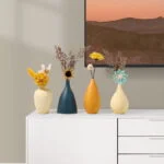 Modern decorative vases with flowers on a white cabinet, enhancing home decor.