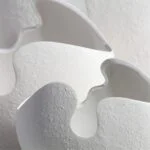 Close-up of modern white ceramic vase with textured surface.