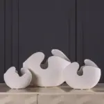 Modern white ceramic vases with abstract design on a table, perfect for luxury home decor.