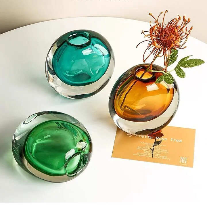Colorful glass vases with flowers on a table, modern home decor.