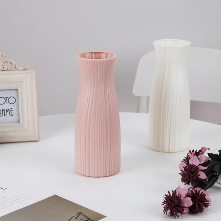 Elegant pink and white ceramic vases on a table with decorative flowers.